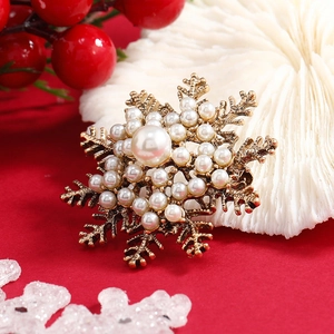Broche flocon de neige vintage avec perles blanches sur base dorée pour Noël élégant