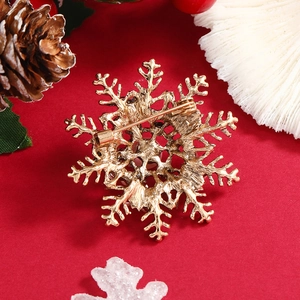 Vue arrière de la broche flocon de neige avec fermoir sur fond rouge festif et décor