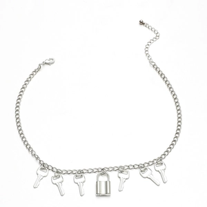 Collar de cadena plateada con múltiples dijes de llave y un colgante de candado central en blanco