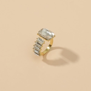 Chic gold-plated geometric ring with emerald-cut zircon stones on a soft beige background