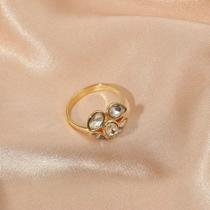 Elegant gold flower ring with crystal clusters on champagne silk background