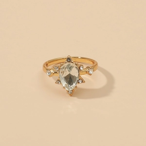 Retro geometric gold ring featuring a pear-cut crystal surrounded by small diamonds
