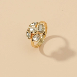 Elegant gold cluster ring with pear and marquise cut diamonds on a beige background