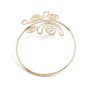 Macro detail van gepolijste gouden spiraalarmband met bohemien golfpatronen op wit