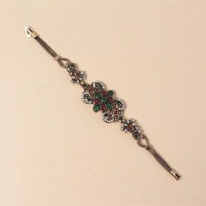 Detail eines Vintage-Boho-Armbands mit hohlem Blumendesign und bunten Straßsteinen