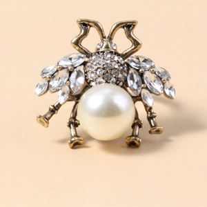 Vintage golden bee brooch with white pearl abdomen and sparkling crystal wings