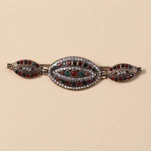 Detailansicht des Vintage-Bronze-Armbands mit roten und grünen Strasssteinen besetzt