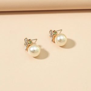 Stijlvolle vlinder pareloorbellen met gekleurde strass steentjes op beige achtergrond
