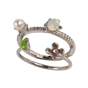 Detail of silver-plated bypass ring with pearl, green enamel leaf and floral zircon