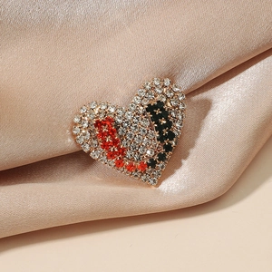 Spilla a cuore scintillante con strass e lettera U su un lussuoso tessuto di raso