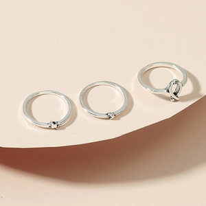 Three-piece silver minimalist ring set featuring ribbon design and sleek metal bands