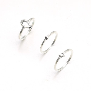 Three-piece set of vintage silver geometric rings featuring heart, star, and fish knot charms