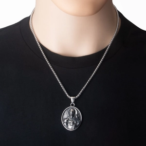 Detailed view of vintage religious saint medallion on stainless steel beaded chain