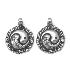 Detail of vintage stainless steel Yin Yang pendants with antique finish and wave texture