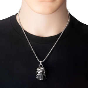 Gros plan détaillé d'un collier avec pendentif tête de mort argenté sur un t-shirt noir rétro