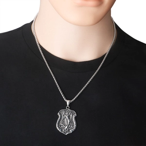Detail of St. Michael shield pendant on stainless steel box chain over black shirt