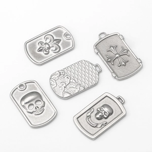 Five vintage silver stainless steel shield pendants featuring cross, waves and skull motifs