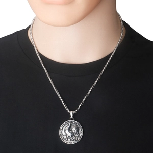 Détail macro du pendentif pièce coq en acier inoxydable argenté avec texte embossé