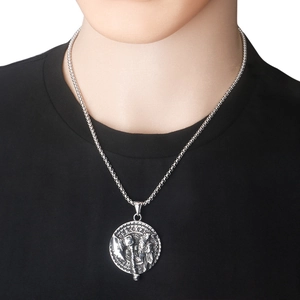 Detalle del colgante de hacha vikinga de acero inoxidable con runas grabadas sobre camiseta