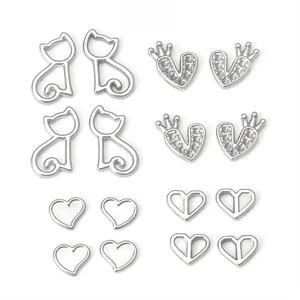 Détails macro de divers pendentifs en acier inoxydable argenté en forme de chat et cœur