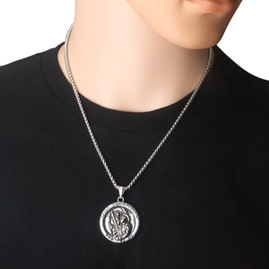Detailed close-up of Saint Christopher religious medallion on a vintage silver chain