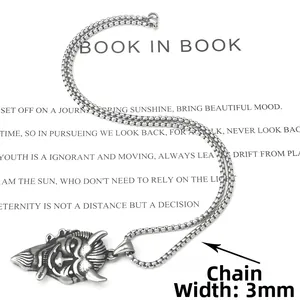Vue détaillée du pendentif punk démon rétro avec chaîne box de 3 mm sur fond de livre