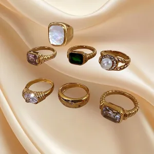 Set of seven 18K gold plated stainless steel rings with zircon and emerald stones