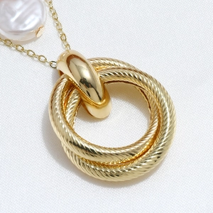 Collar de doble capa dorado con anillos entrelazados texturizados y detalle de perla