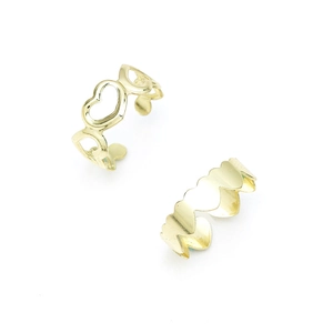 Detail view of two gold hollow heart-shaped alloy toe rings on white background