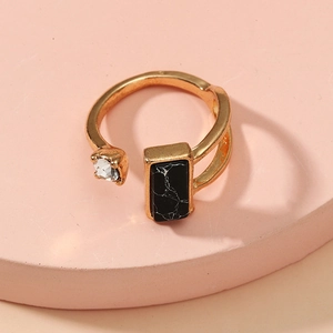 Adjustable gold ring with a clear zircon and rectangular marble stone on pink podium