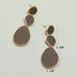 Detail view of geometric leather earrings with gold edges and brown lychee texture
