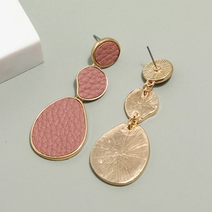 Detail of pink lychee leather earrings with brushed gold-toned metallic backing