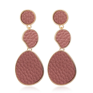 Detailed view of long tiered drop earrings with pink litchi grain leather and gold metal