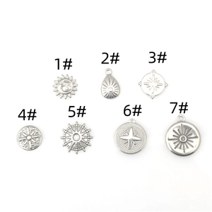 Detalle de siete colgantes de acero inoxidable con motivos de sol y luna para joyería