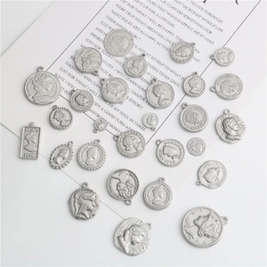 Macro view of vintage stainless steel coin pendants with embossed queen and crest patterns
