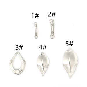 Vue macro de cinq pendentifs assortis en acier inoxydable argenté en forme de feuilles