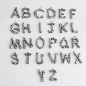 Detailed macro view of 26 bamboo-style metal letter pendants for DIY jewelry making
