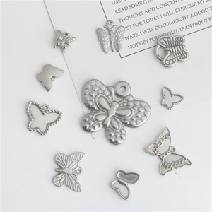 Lot de dix pendentifs papillon en acier inoxydable pour création de bijoux sur fond blanc