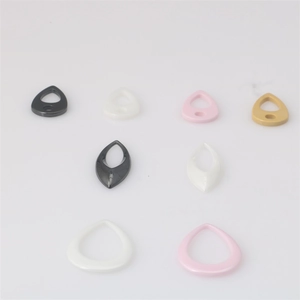 Detailansicht von Tropfen-Keramik-Anhängern in Schwarz, Weiß, Rosa und Gold für DIY-Schmuck