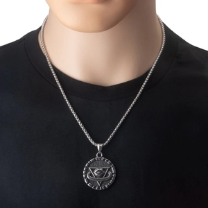 Detail of vintage stainless steel All-Seeing Eye pendant necklace on a black shirt