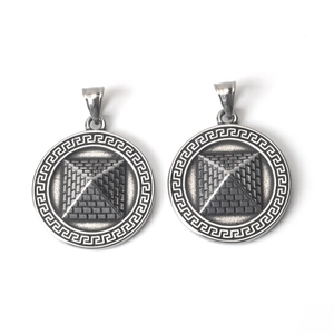 Macro detail of vintage silver pyramid pendants with Greek key border patterns