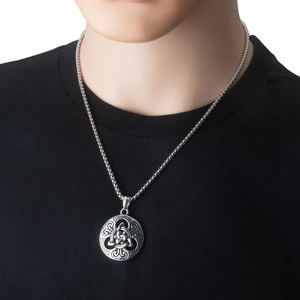 Détail d'un pendentif circulaire nœud celtique en acier sur une chaîne argentée