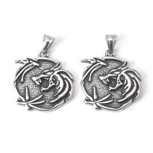 Close-up of vintage punk dragon-engraved pendants with detailed black-toned scales