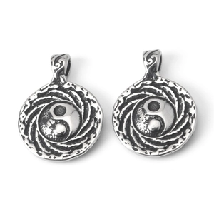 Détail macro de pendentifs Yin Yang en acier inoxydable vintage avec gravure en spirale