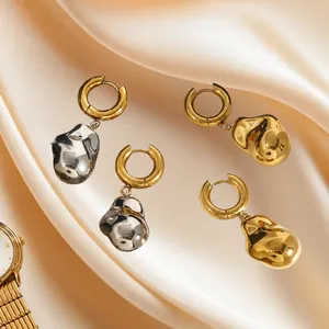 Boucles d'oreilles de luxe or et argent sur soie beige avec une montre élégante