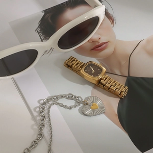 Golden square watch with silver heart pendant necklace and white oval sunglasses