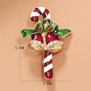 Détails d'une broche cloche de Noël émaillée rouge mesurant 5,2 cm par 3,6 cm environ