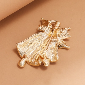 Broche cloche de Noël dorée avec fermoir épingle sur un fond marron chaud élégant