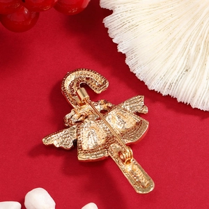 Vue arrière de la broche sceptre cloche de Noël dorée avec fermoir épingle sur rouge