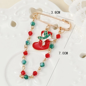 Vintage Christmas boot pin with red green beads and enamel pendant in a macro view